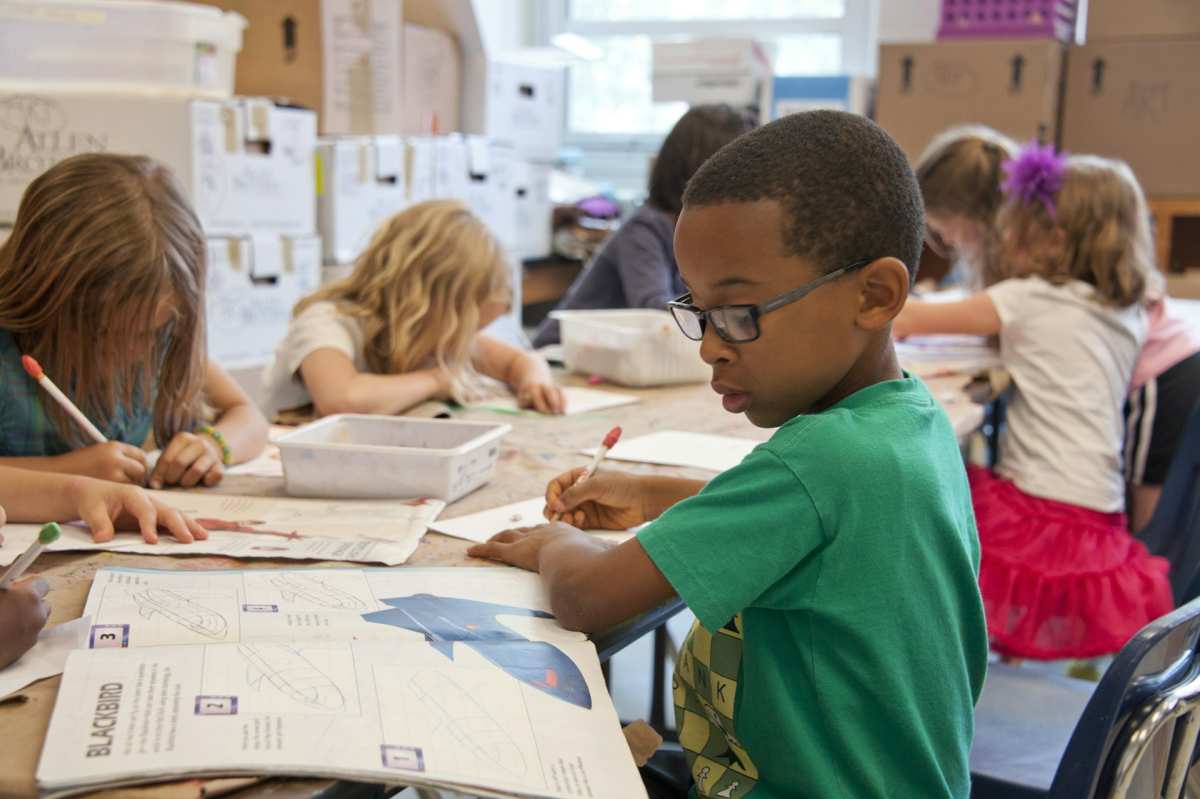 kids sitting and doing schoolwork in a classroom