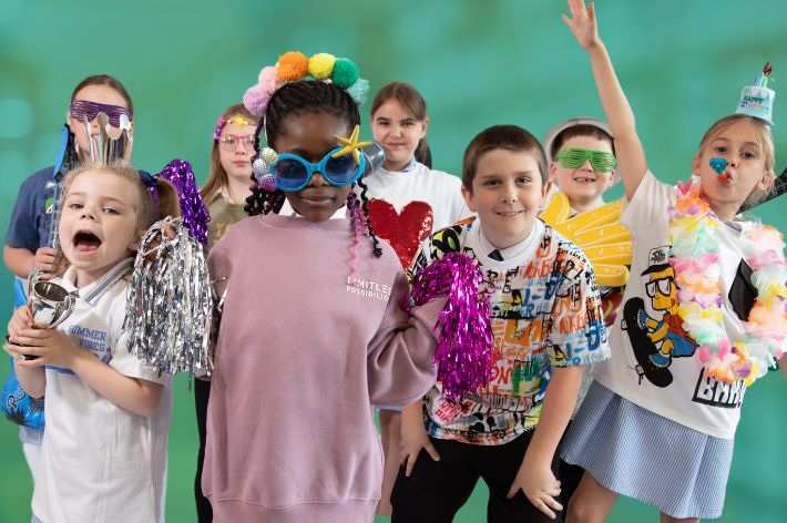 group of children aged 7-9 in party clothes having fun