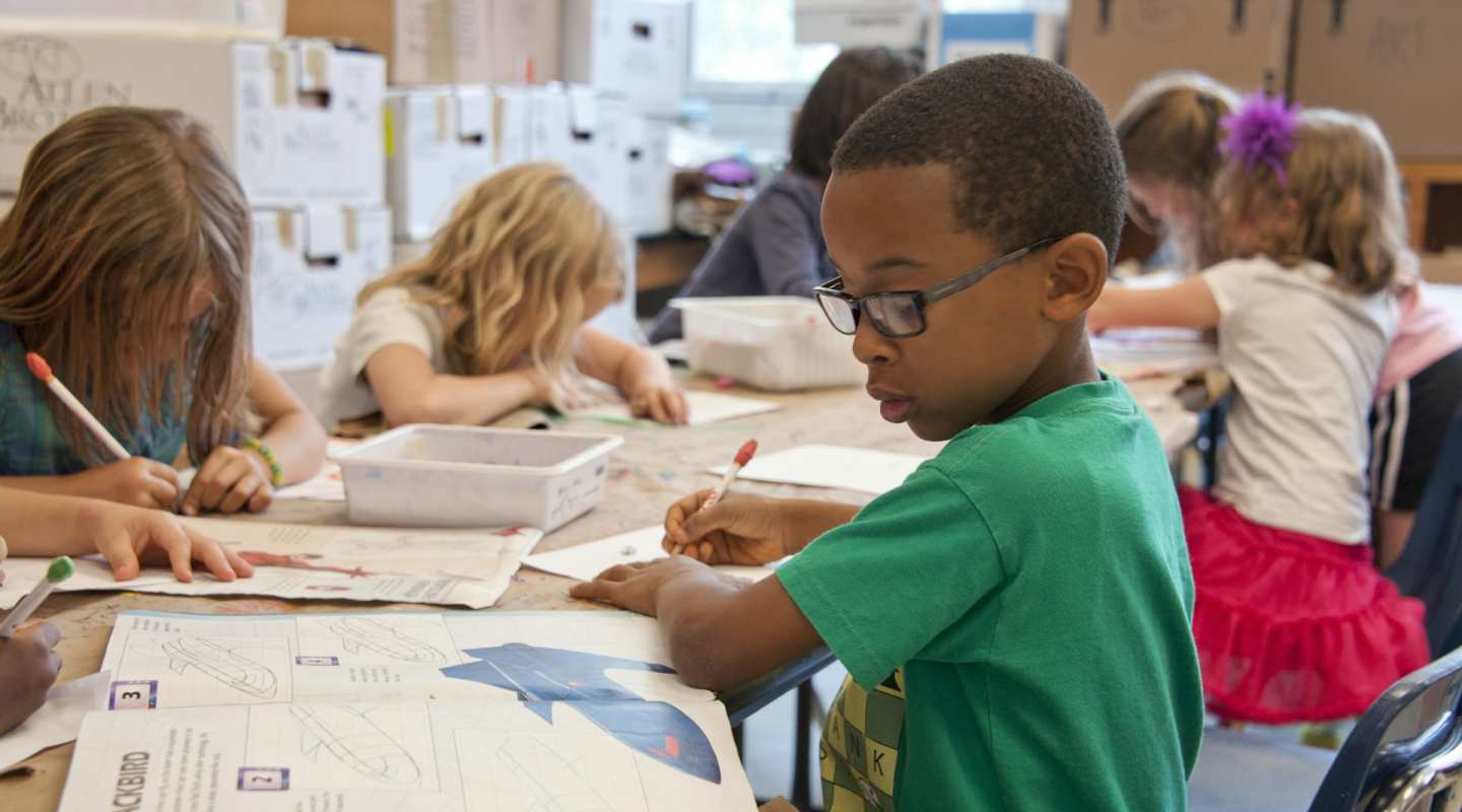 kids sitting and doing schoolwork in a classroom