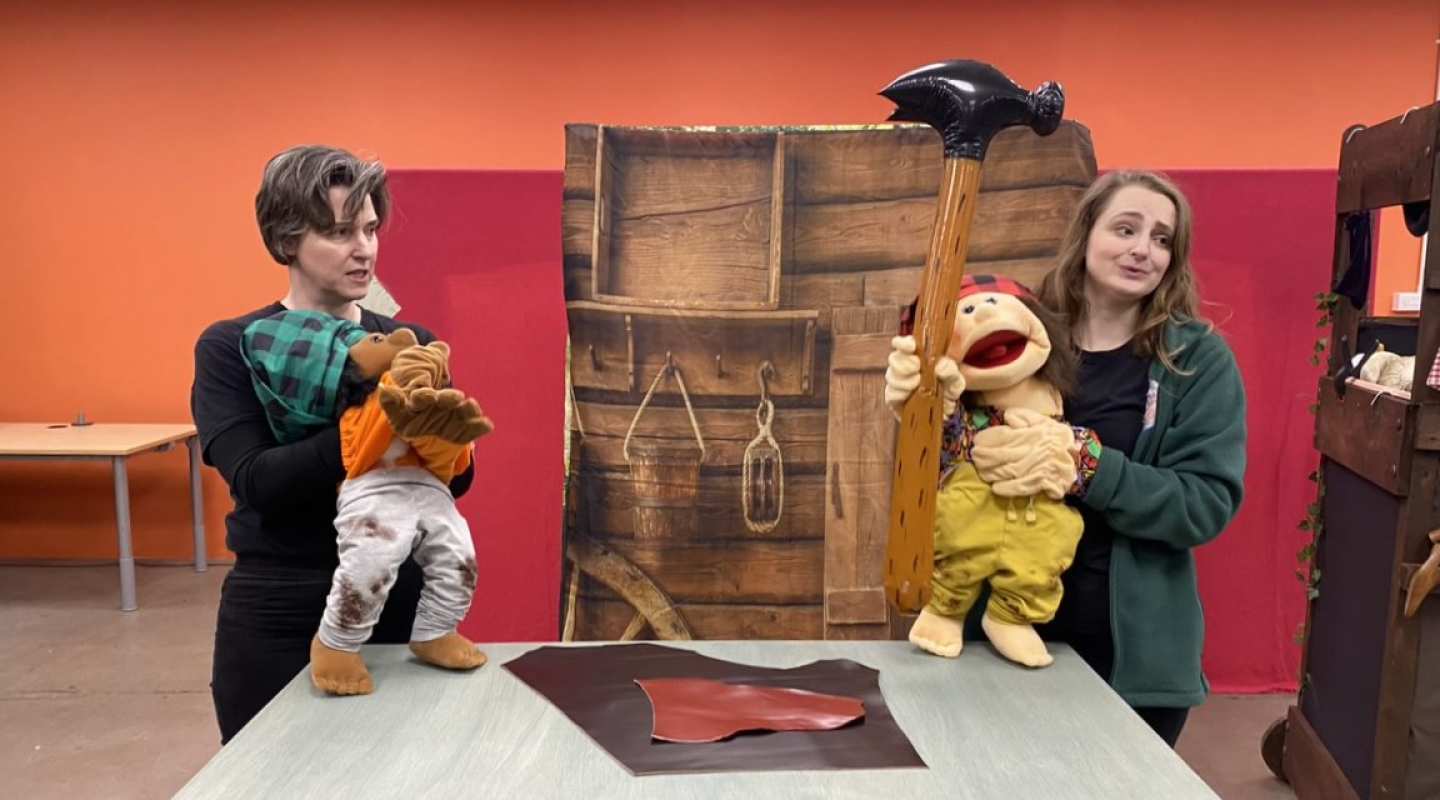 2 women with a large puppet each on stage during a theatre performance